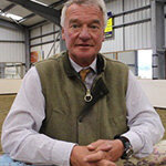 Headshot of Yogi Breisner, freelance coach and a Trustee of the British Horse Foundation, wearing a green waistcoat over a white shirt.
